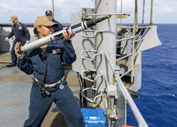 A naval officer prepares to launch an Acoustic Device Countermeasure (ADC) torpedo countermeasure from the bridge wing of the amphibious dock landing ship USS Ashland (LSD 48) during a 2019 training exercise. A naval officer prepares to launch an Acoustic Device Countermeasure (ADC) torpedo countermeasure from the bridge wing of the amphibious dock landing ship USS Ashland (LSD 48) during a 2019 training exercise.