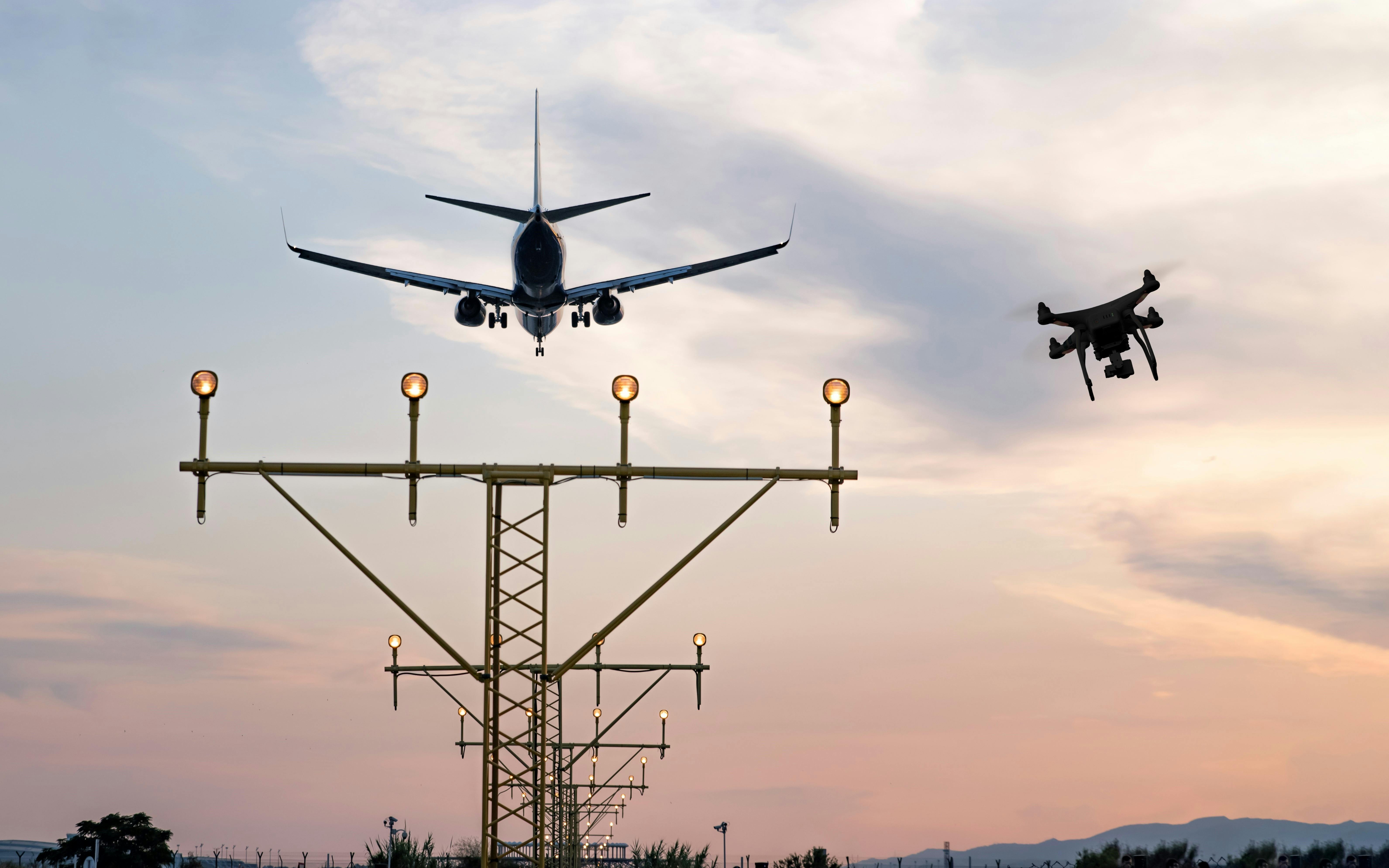 Drone flying at the airport near an aircraft leading to a possible crash or accident. Illegal UAV flight inside the airport conceptual montage