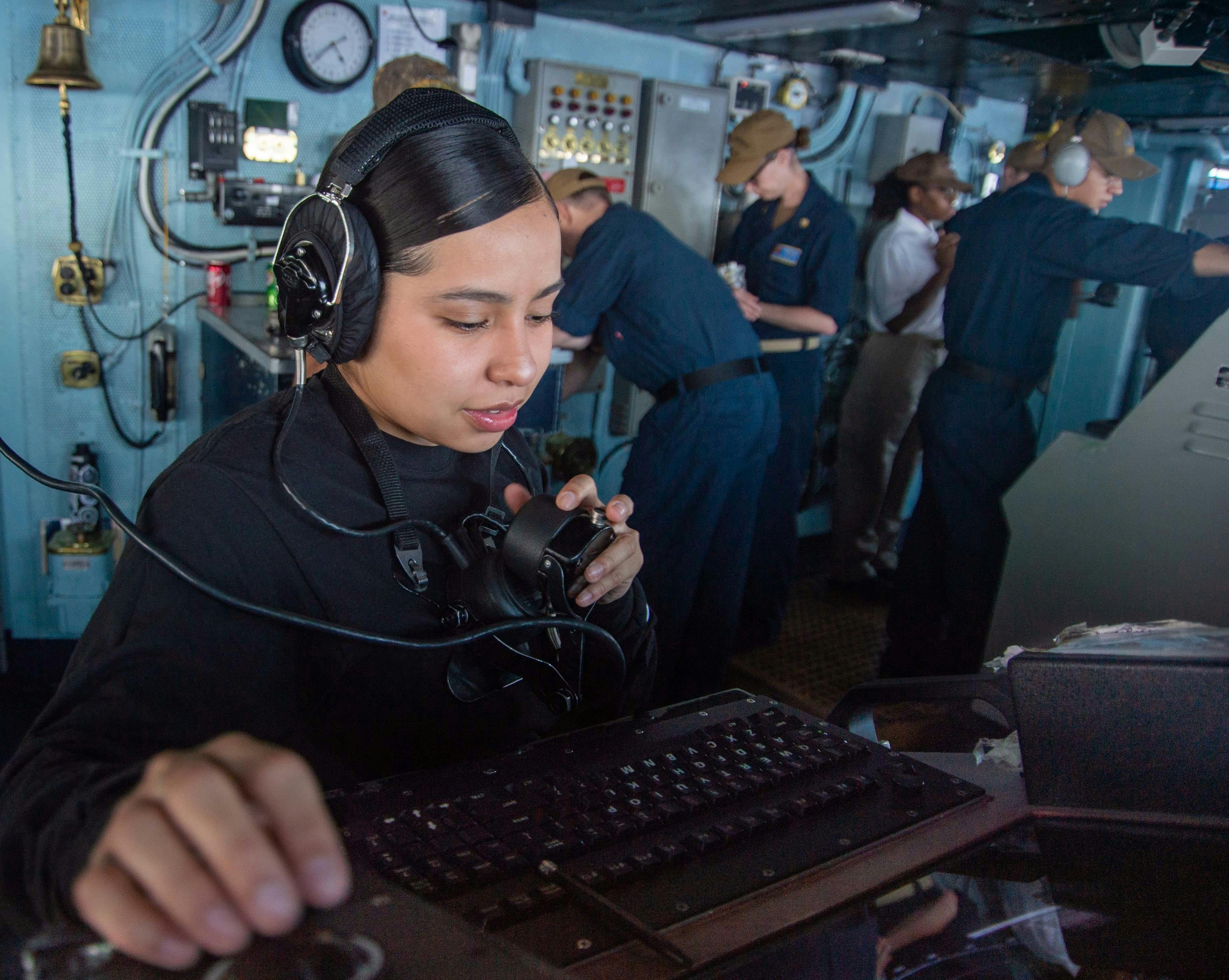 A Navy operations specialist seaman operates the AN/SPS-73(V)12 RADAR SET ON THE bridge of aircraft carrier USS Harry S. Truman (CVN 75) in June 2022.