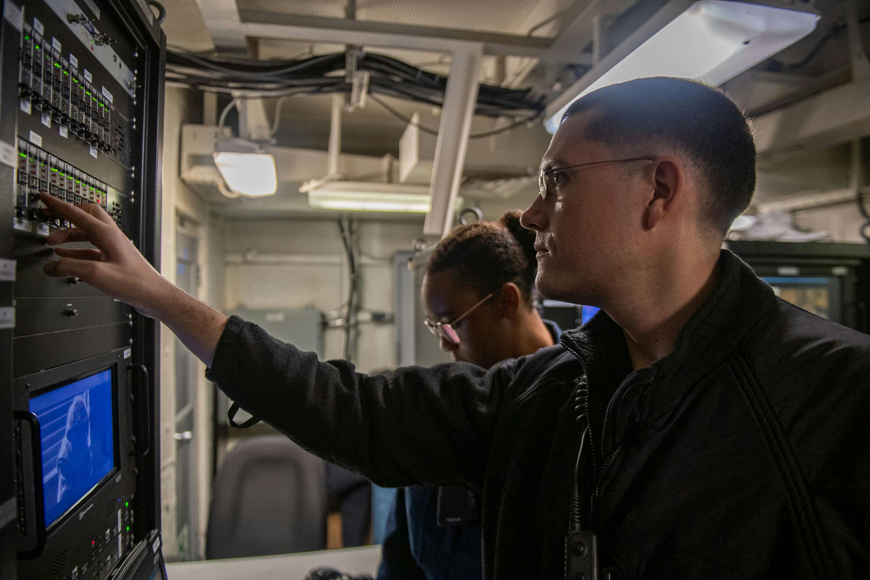 U.S. Navy interior communications electricians conduct maintenance programming on the shipboard information, training, and entertainment closed circuit television system aboard the Nimitz-class aircraft carrier USS Theodore Roosevelt (CVN 71) last August.