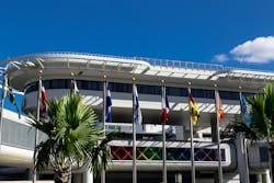 An exterior photo of MIA with international flags on poles outside. An exterior photo of MIA with international flags on poles outside.