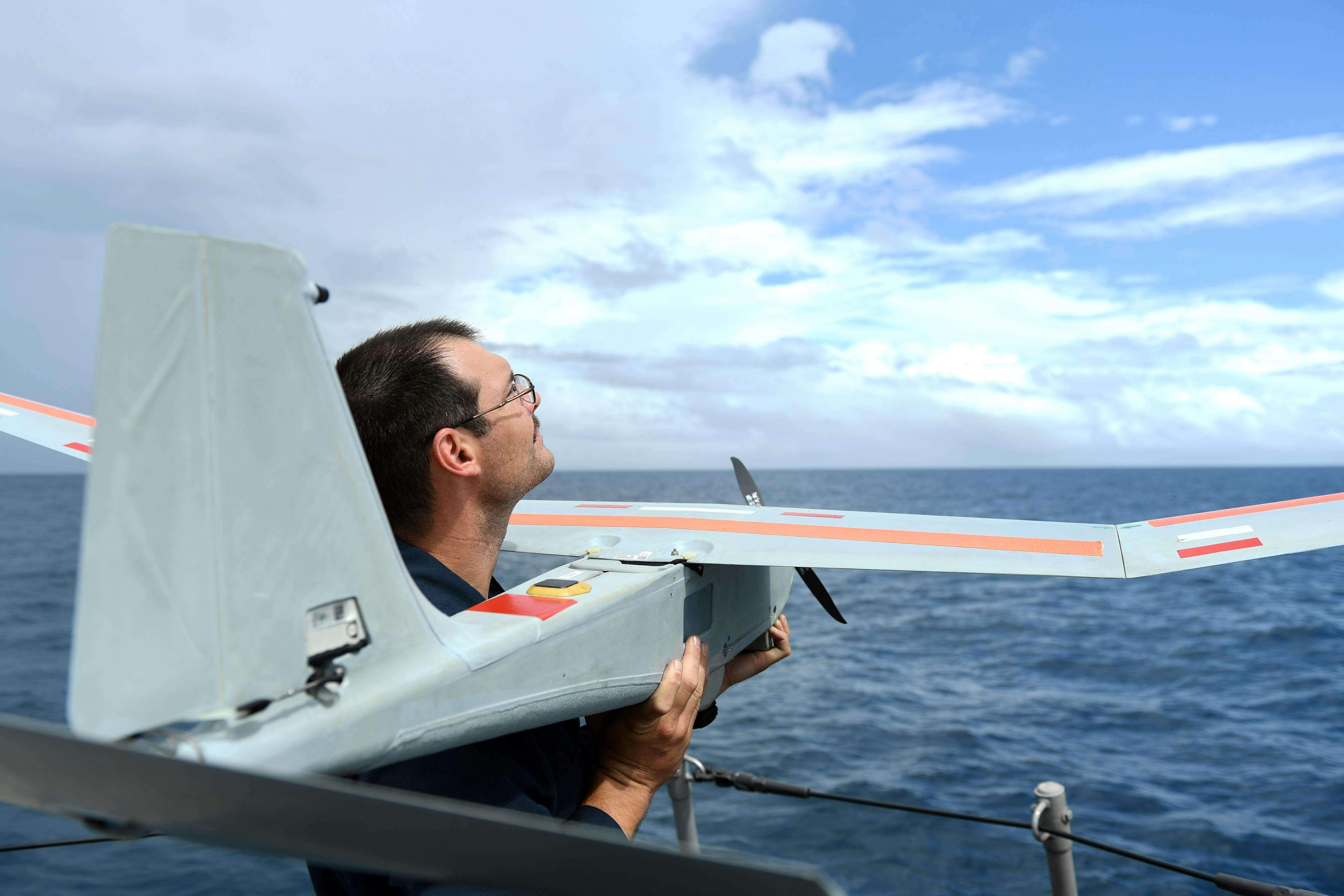 A Navy electronics technician prepares to launch the PUMA AE short-range tactical uncrewed aircraft from the Cyclone-class coastal patrol ship USS Tornado (PC 14).