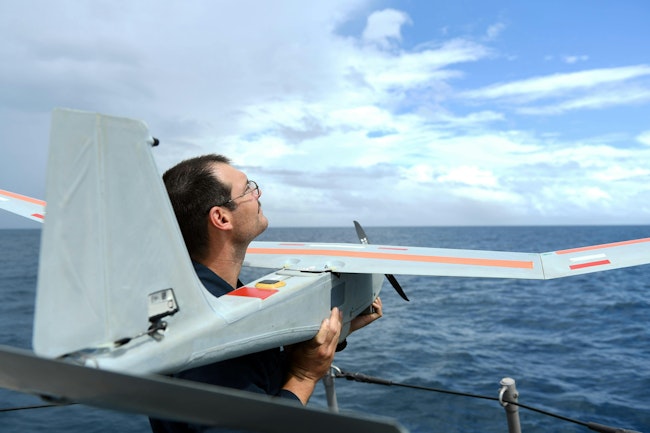 A Navy electronics technician prepares to launch the PUMA AE short-range tactical uncrewed aircraft from the Cyclone-class coastal patrol ship USS Tornado (PC 14).