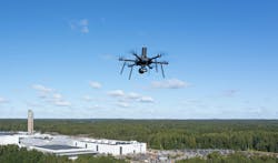 A small electric UAV flies at an industrial site. A small electric UAV flies at an industrial site.