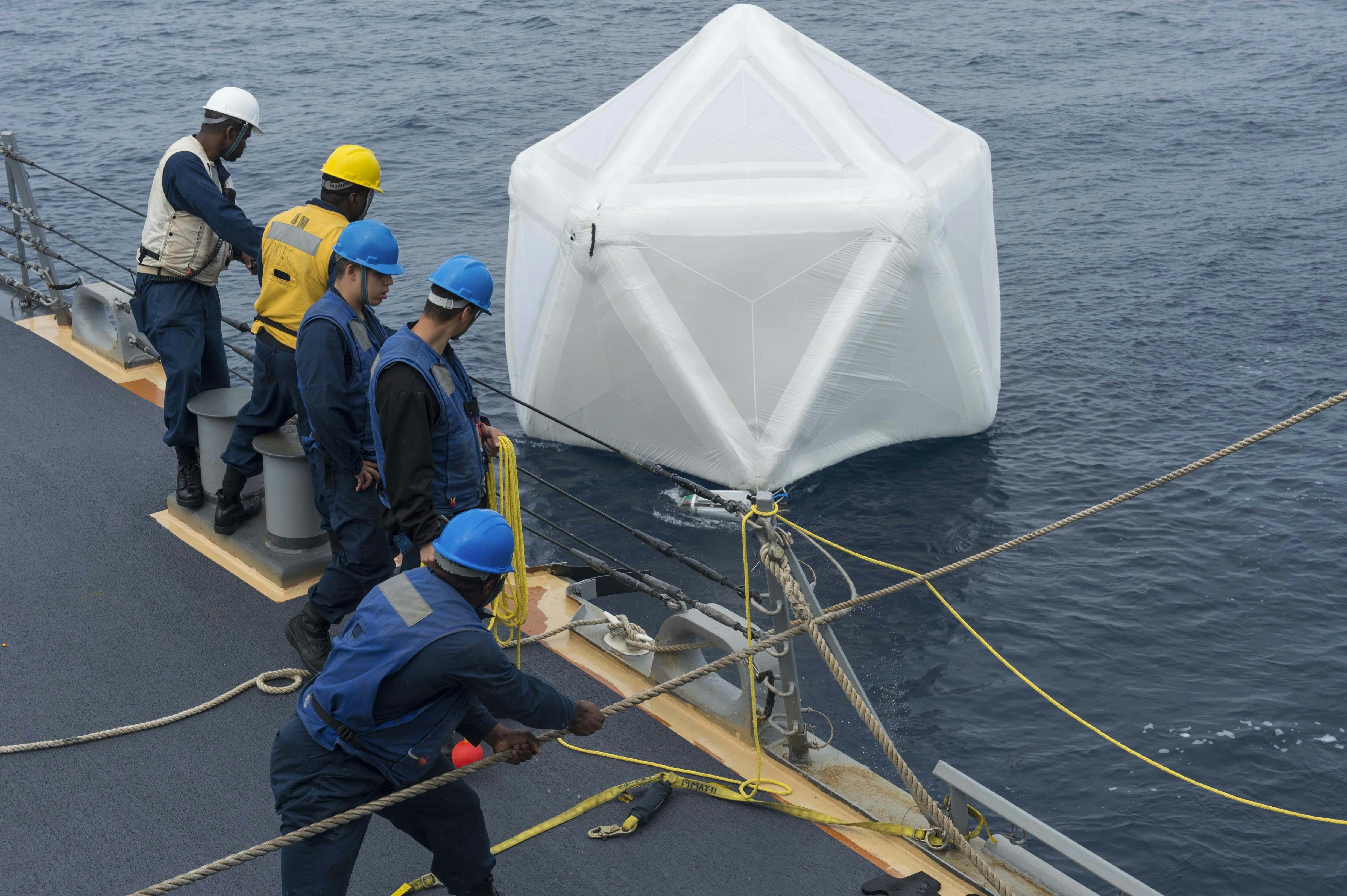 Sailors aboard the Arleigh Burke-class guided-missile destroyer USS Ramage (DDG 61) recover an inflated decoy during an initial test of the Mk-59 decoy launch system in 2014