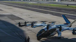Two people approach an Archer eVTOL on the tarmac.