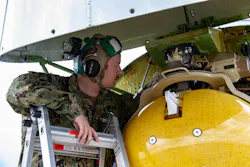 A U.S. Navy aviation electronics technician performs maintenance on the AN/APY-10 radar of a P-8A Poseidon at Royal Air Force Base Lossiemouth, Scotland, in 2023.