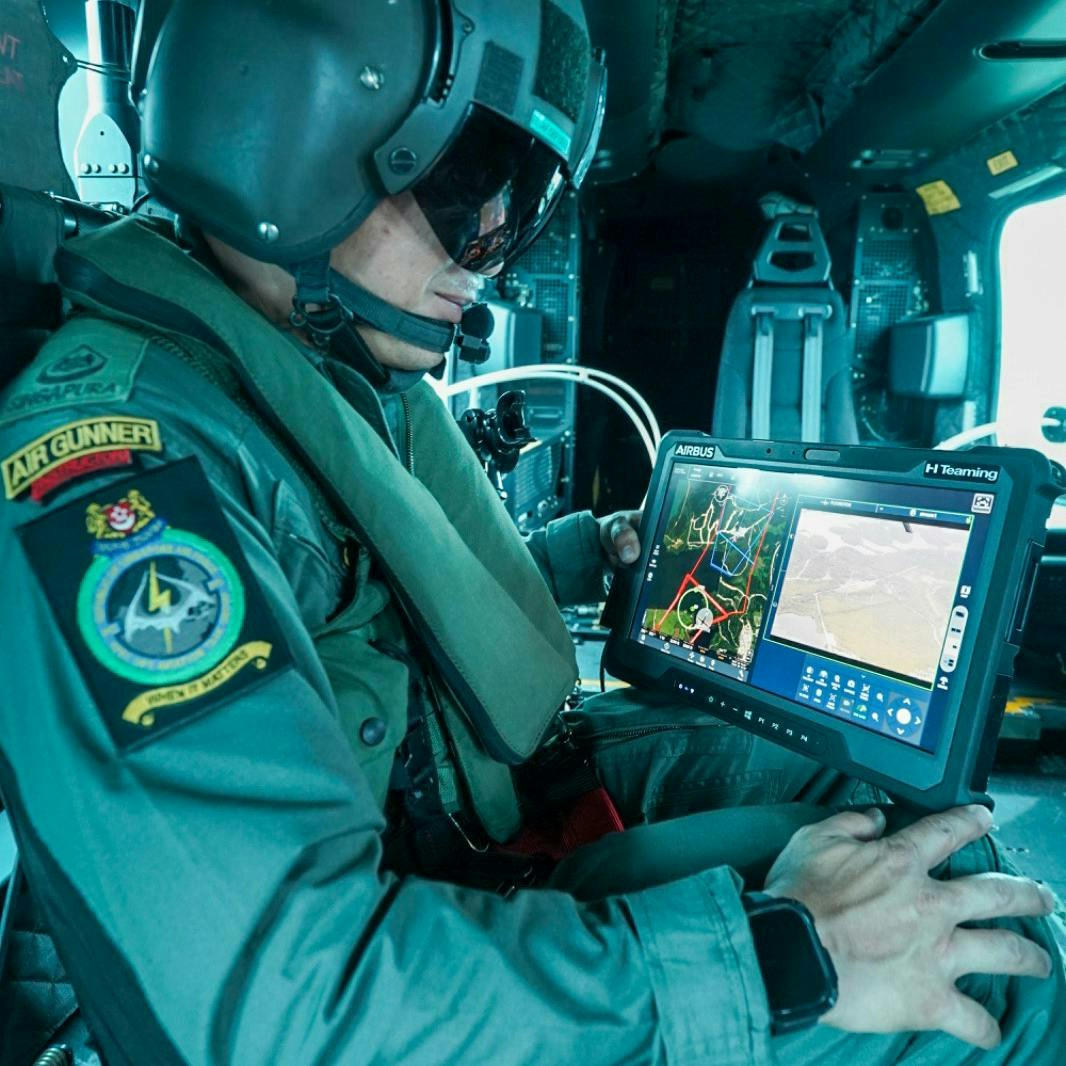 An operator in a helicopter looks at a screen while demonstrating crewed-uncrewed teaming.