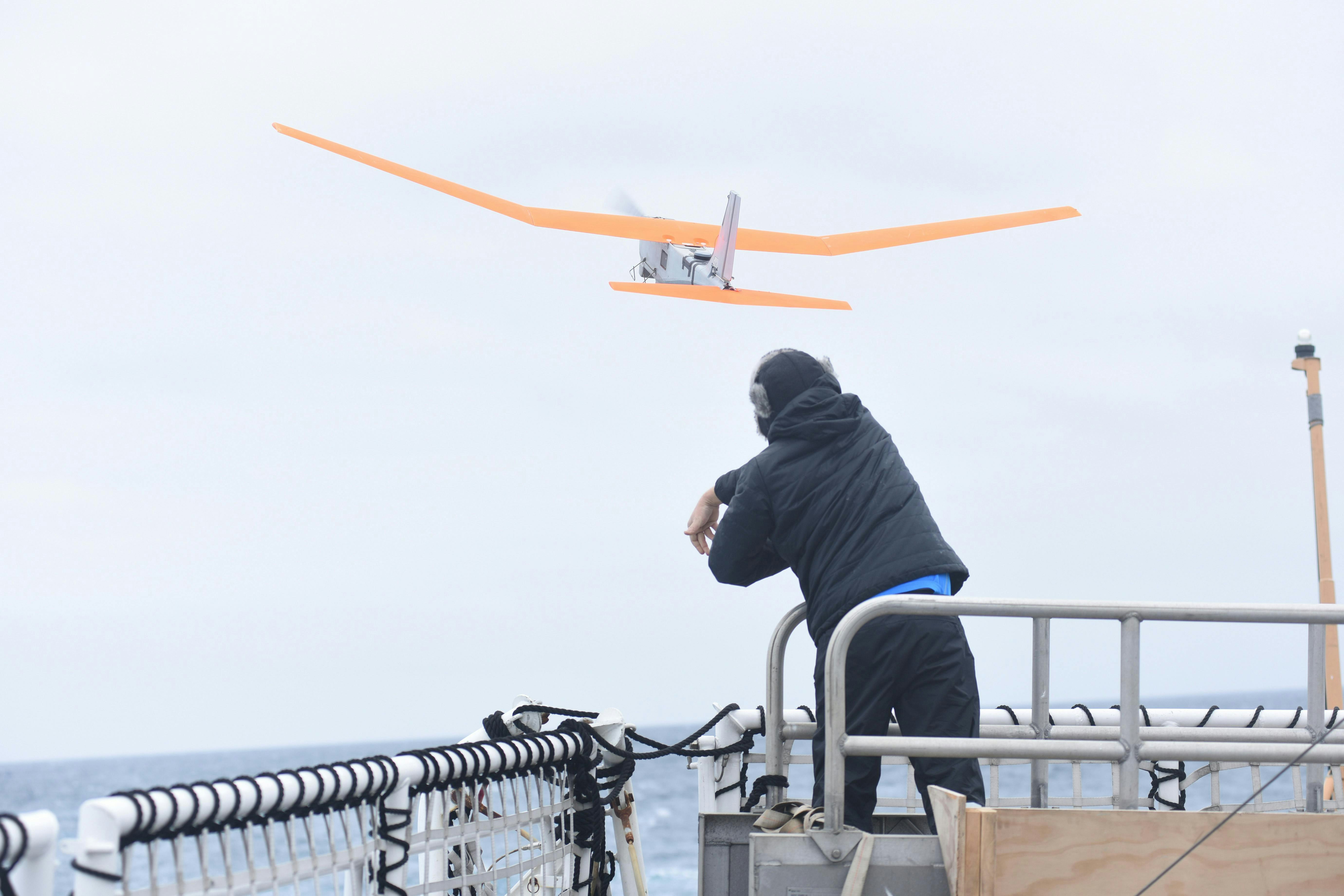 An engineering development technician with AeroVironment Inc. launches a PUMA AE unmanned aircraft from the flight deck of Coast Guard Cutter Polar Star during Operation Deep Freeze 2016.