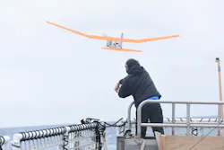 An engineering development technician with AeroVironment Inc. launches a PUMA AE unmanned aircraft from the flight deck of Coast Guard Cutter Polar Star during Operation Deep Freeze 2016.