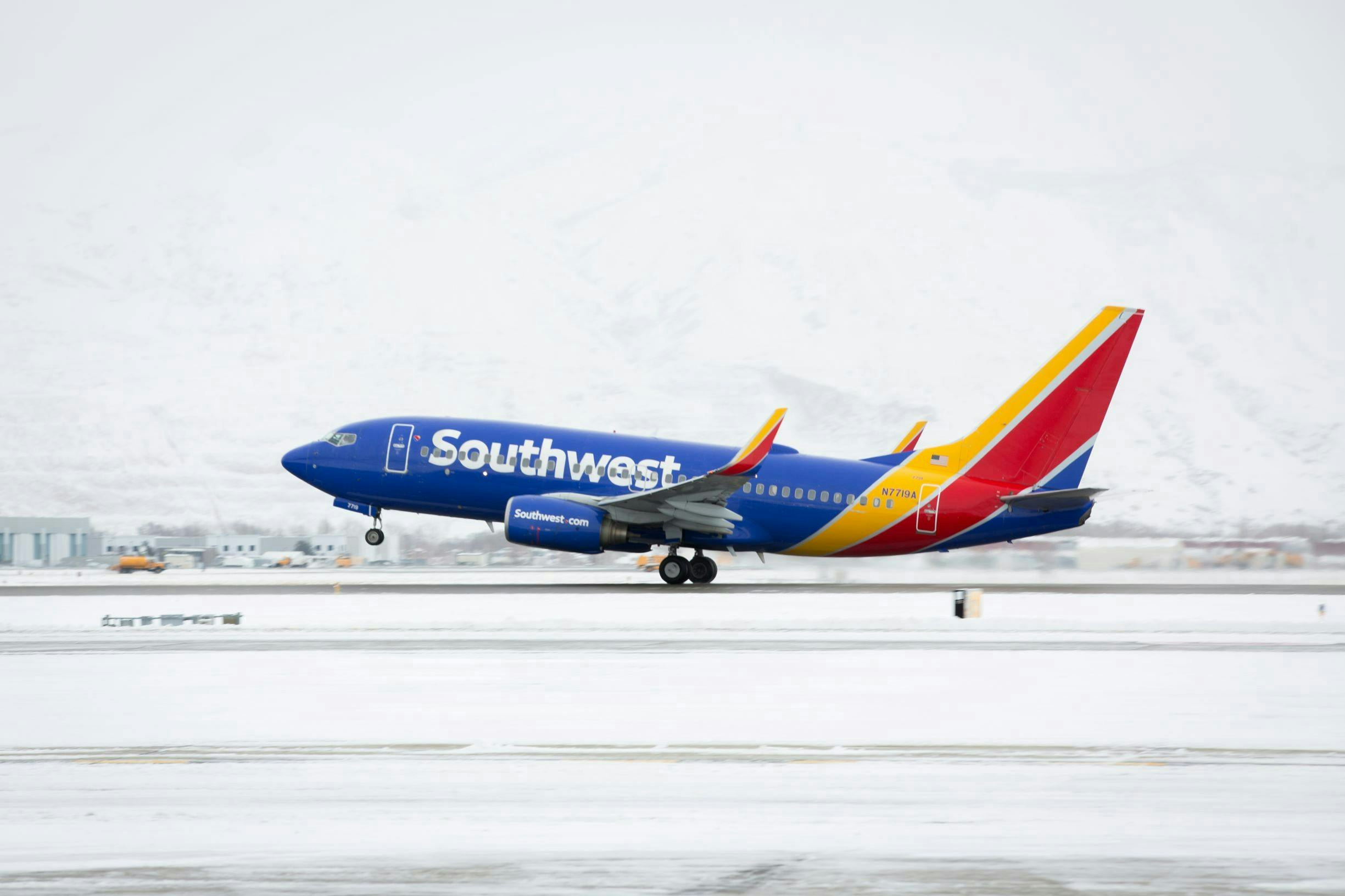 A Southwest passenger aircraft takes off amid a snowy background.