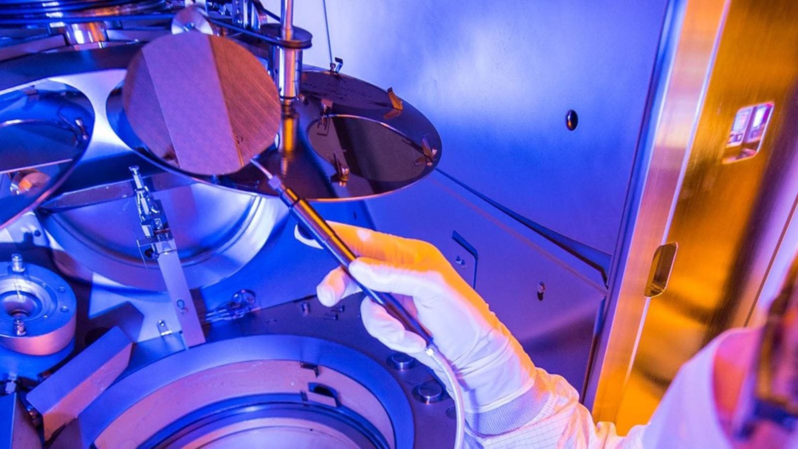 A wafer in a lab environment being held by a person.