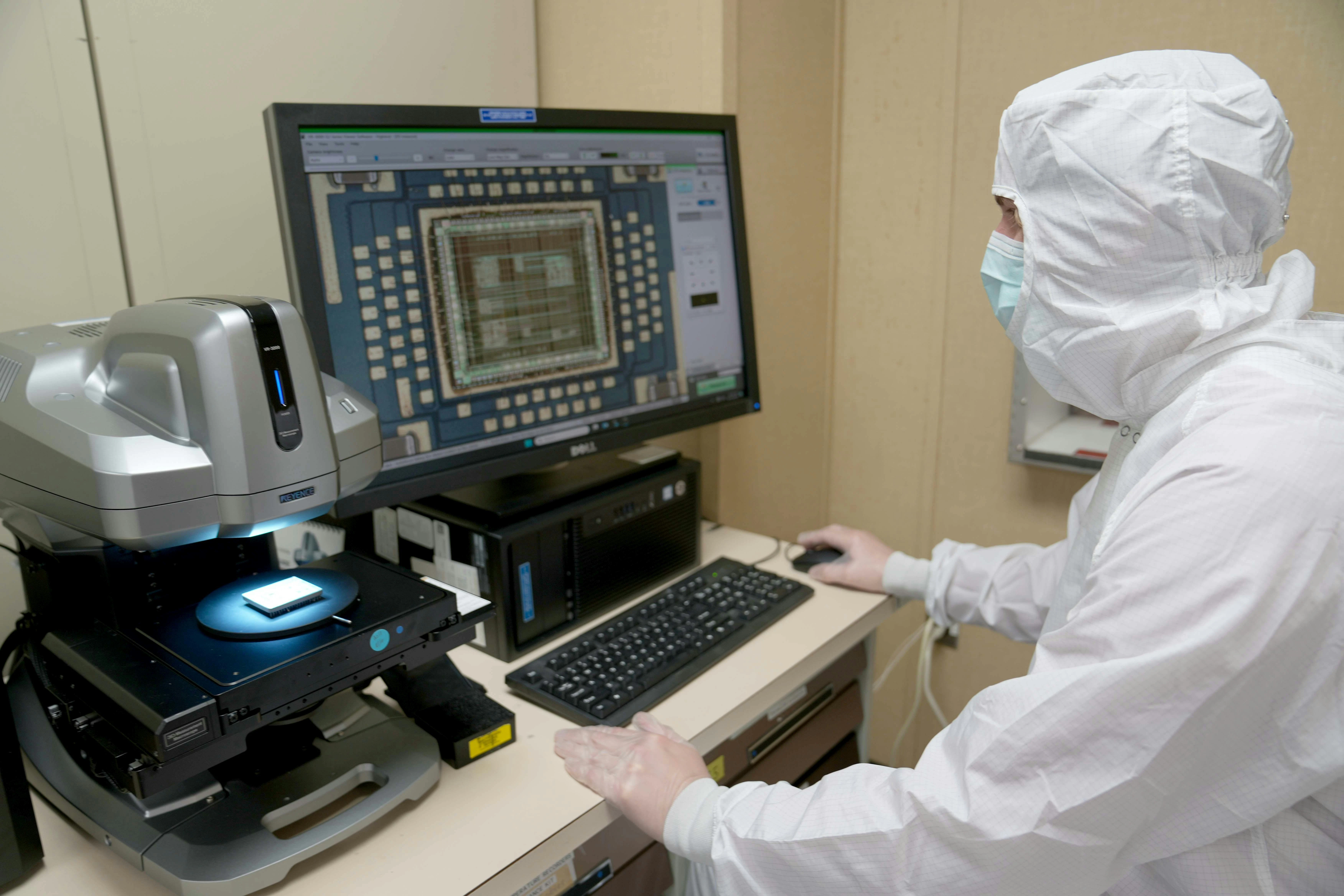 A military electronics engineer performs a visual inspection of a hybrid microcircuit for defects at Robins Air Force Base, Ga., last June.