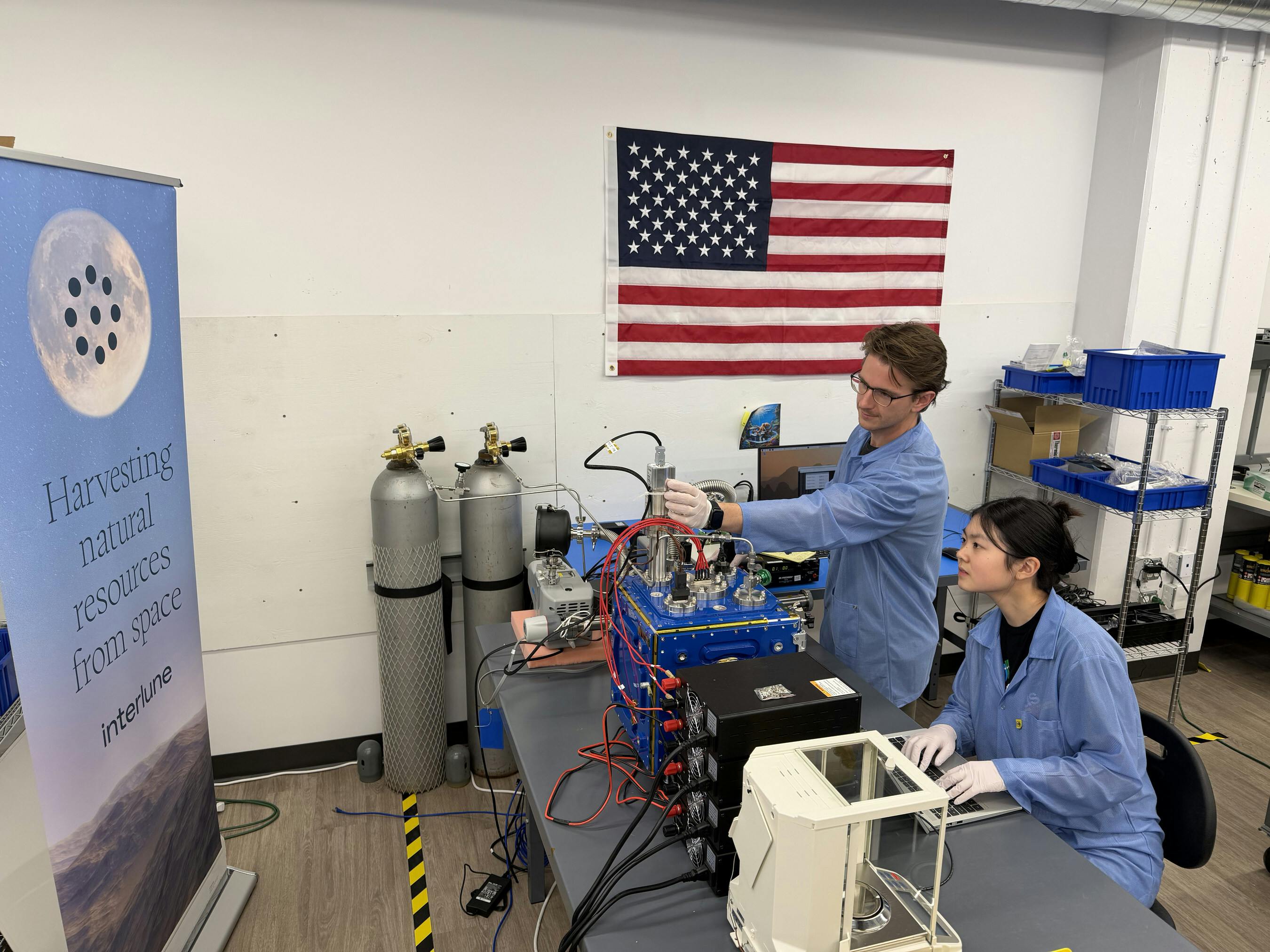 Interlune test engineer Alex Lewandowski (left) and mechanical engineer Jessica Wu (right) check test equipment for the mass spectrometer system in the Regolith Lab at the company&rsquo;s Seattle headquarters. Interlune photo.