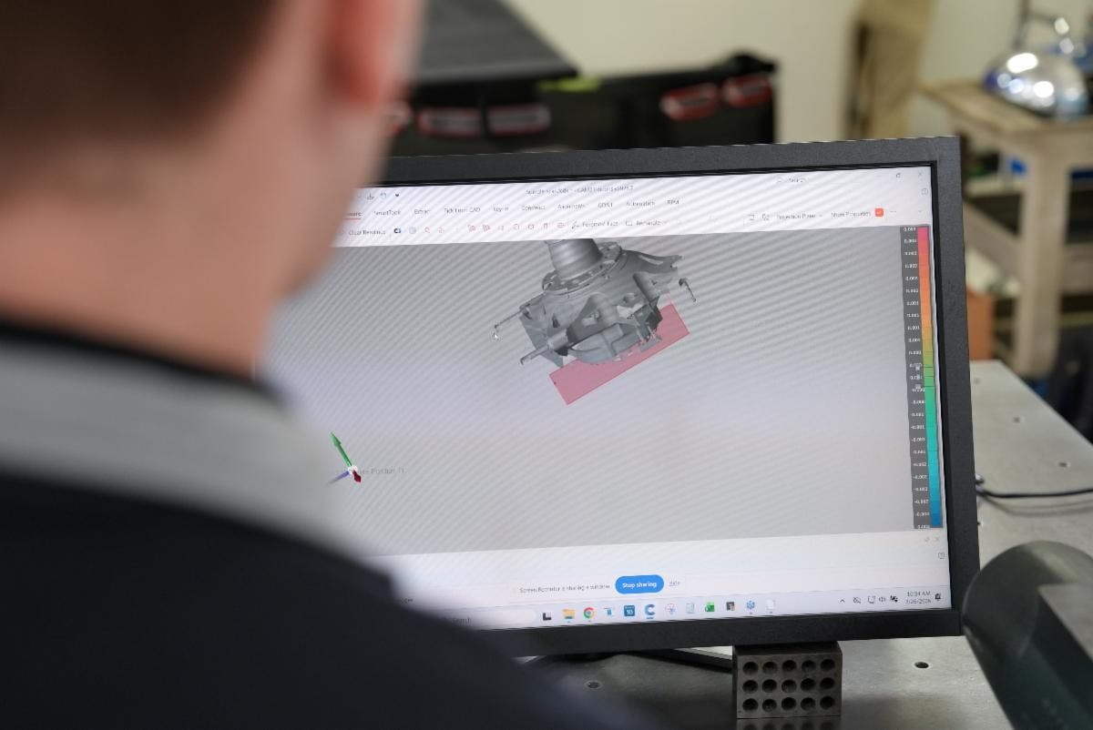 A man looks at a CAD file on a computer screen