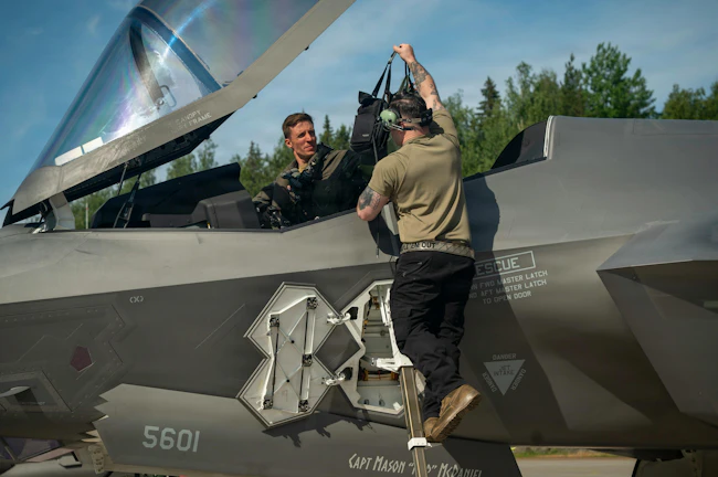 U.S. Air Force Staff Sgt. Christian Cornwell, 48th Equipment Maintenance Squadron, assists Capt. Logan Halverson, 493rd Fighter Squadron F-35A Lightning II pilot, during Ramstein Flag 26 at Pirkkala Air Base, Finland. U.S. Air Force photo by Tech. Sgt. Christine Groening.