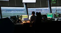 An air traffic controller works at a screen in a tower