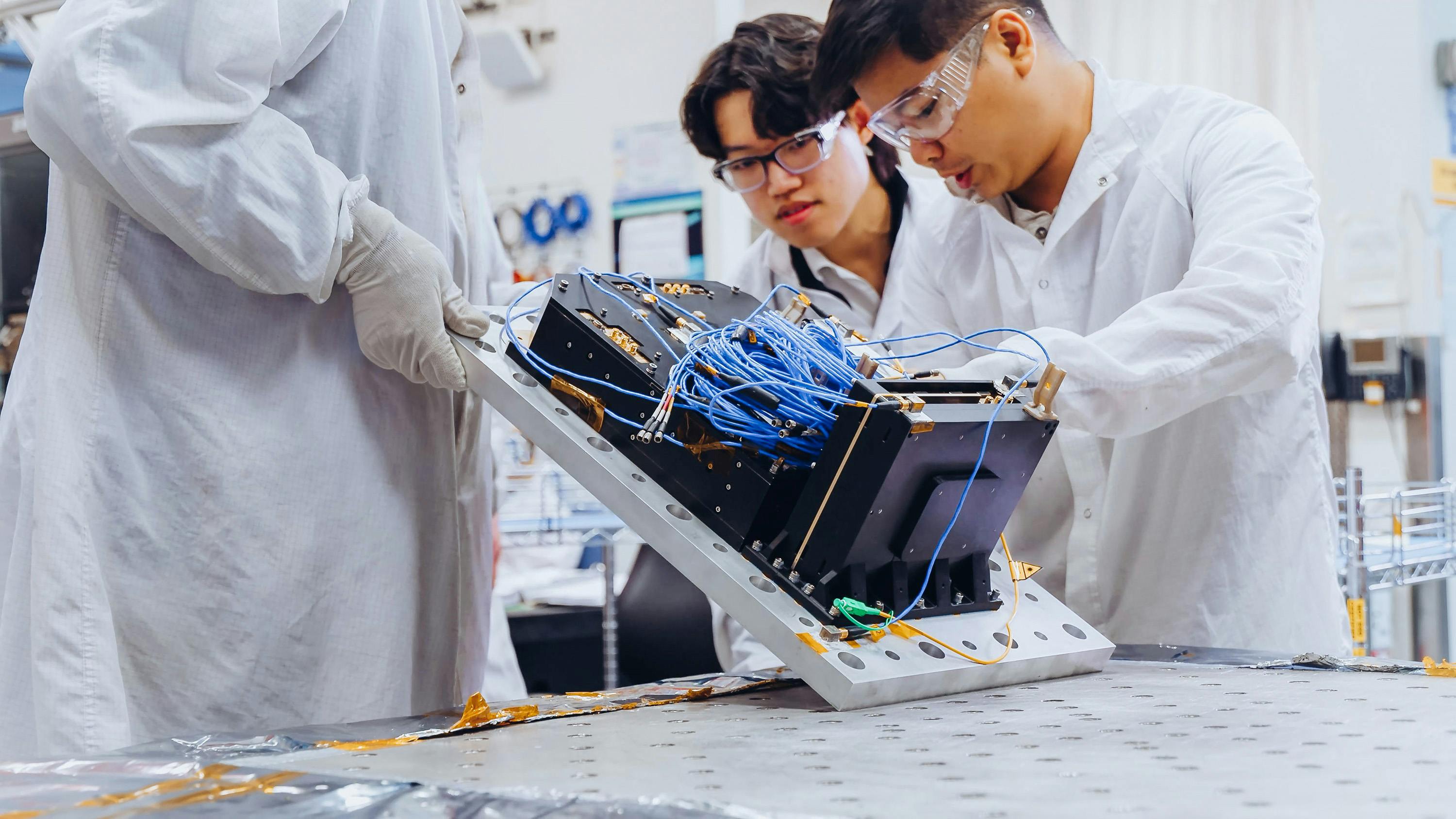 Boeing team members inspect the Q4S flight payload during testing designed to verify the hardware can withstand launch and on-orbit conditions ahead of its planned 2027 mission Boeing photo.