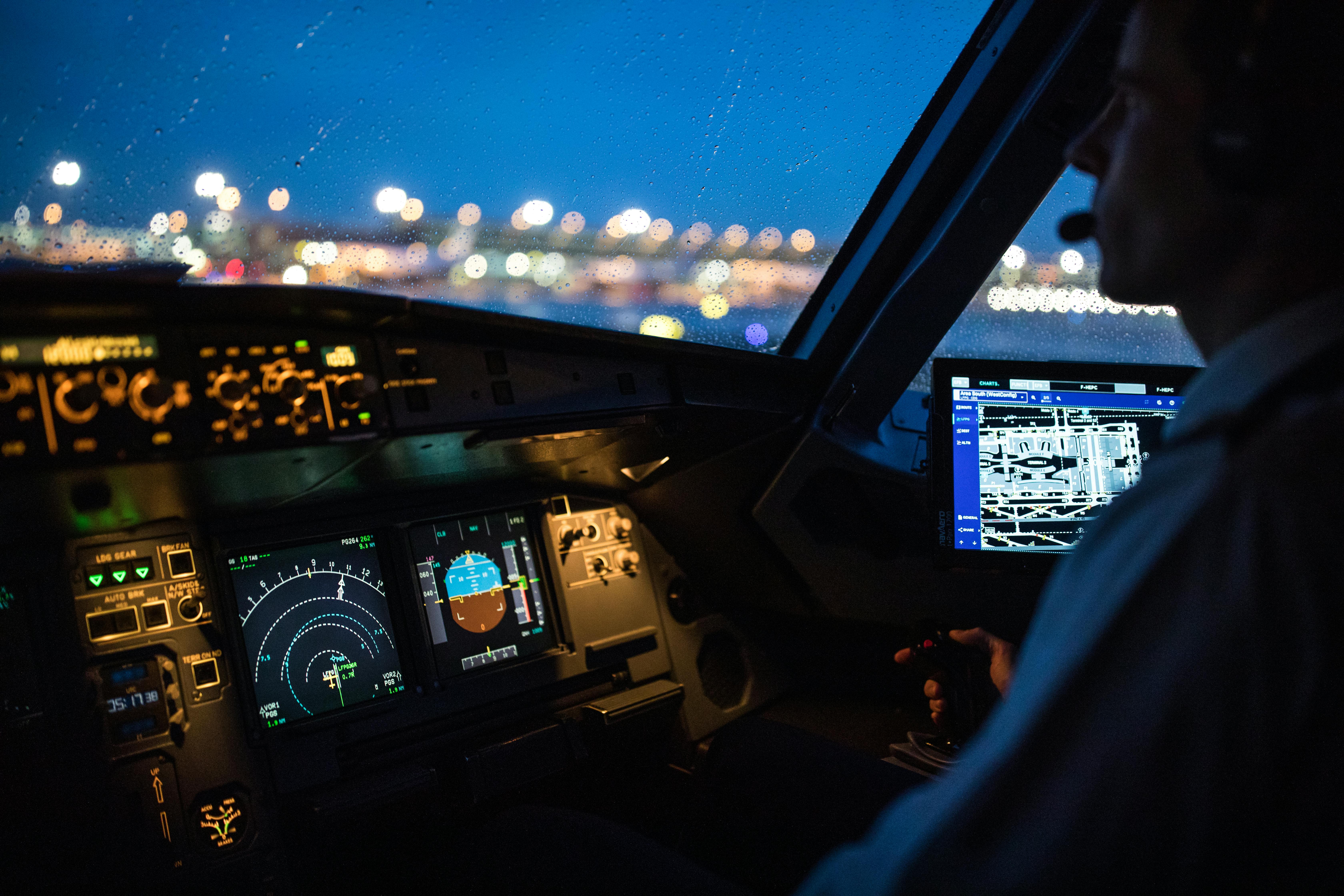 A pilot in a cockpit at night