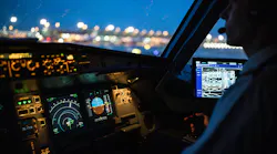 A pilot in a cockpit at night