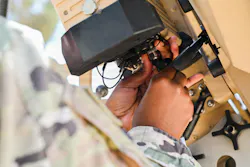A U.S. Air Force client systems specialist wires a satellite communications dish at a base in the U.S. Central Command area of responsibility. U.S. Air Force photo by Staff Sgt. Justin W. Moore.