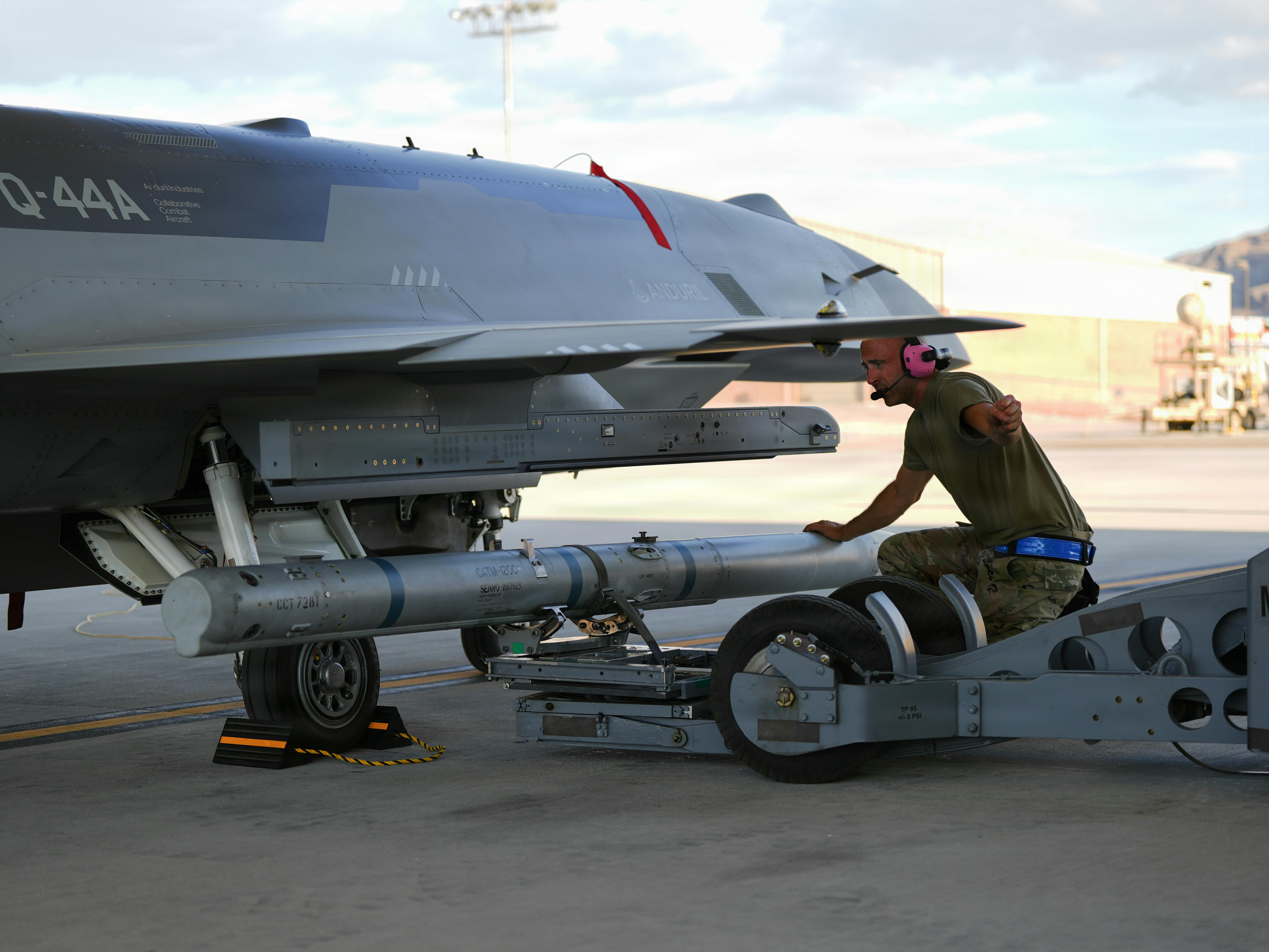 A U.S. Airman assigned to the Collaborative Combat Aircraft Experimental Operations Unit loads an inert missile onto a YFQ-44A Fury aircraft at Creech Air Force Base, Nev. USAF photo by Senior Airman Renee Blundon.