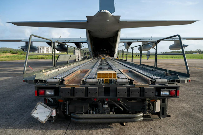 U.S. Marine Corps lance corporals and loadmasters, assigned to the 2nd Marine Aircraft Wing, prepare to offload cargo as part of a resupply run with Contingency Response Element Airmen assigned to the 621st Contingency Response Wing at Jose Aponte De La Torre Airport in Ceiba, Puerto Rico. USAF photo.