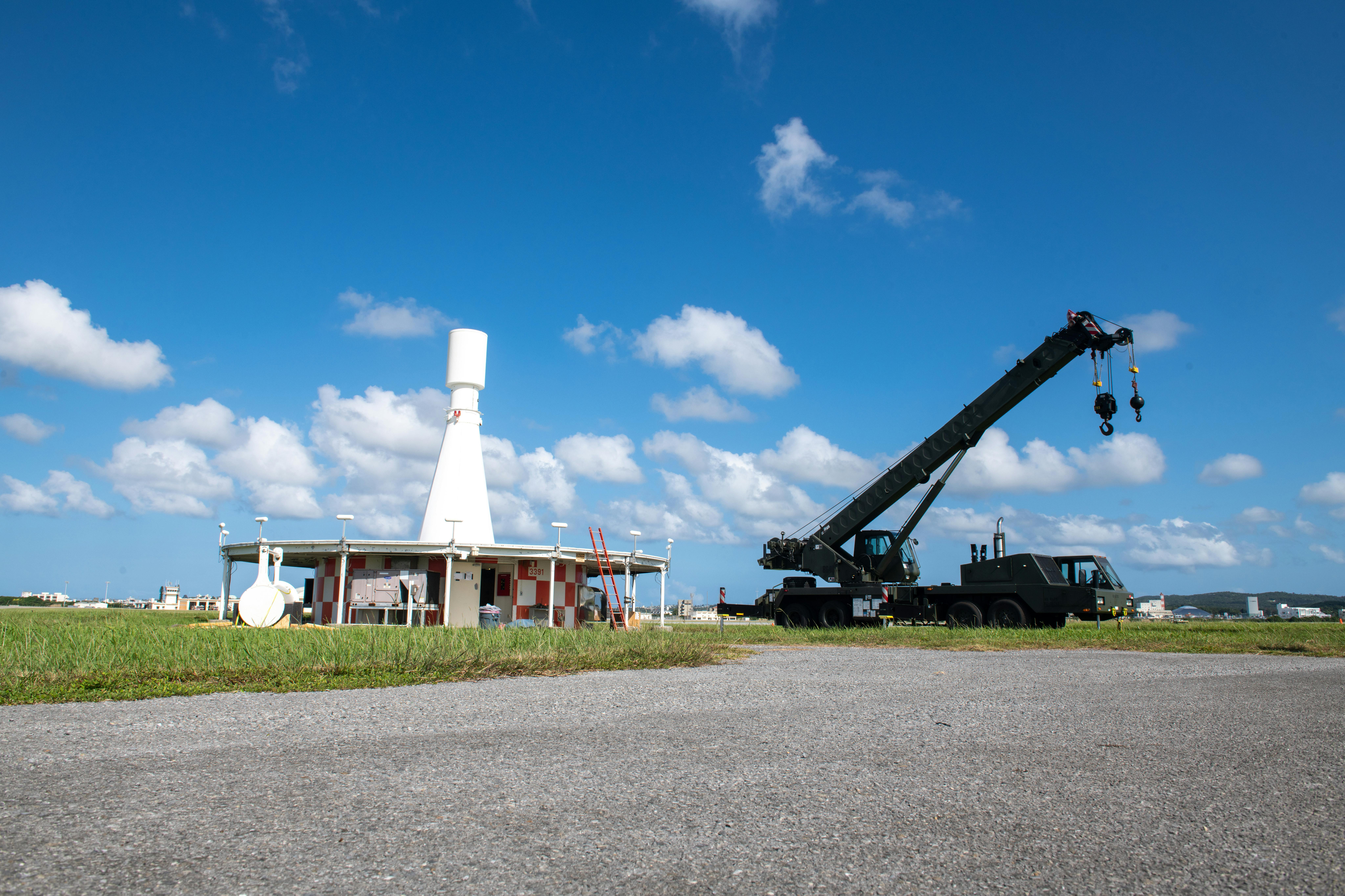 U.S. Air Force Airmen from the 18th Civil Engineering Squadron and U.S. Navy Sailors from the Naval Mobile Construction Battalion 5 prepare to place a new antenna on the Very High Frequency Omnidirectional Range Tactical Air Control system at Kadena Air Base, Japan. The VORTAC consists of two beacons that provide navigational aid to civil and military aircraft. U.S. Air Force photo by Airman 1st Class Moses Taylor.