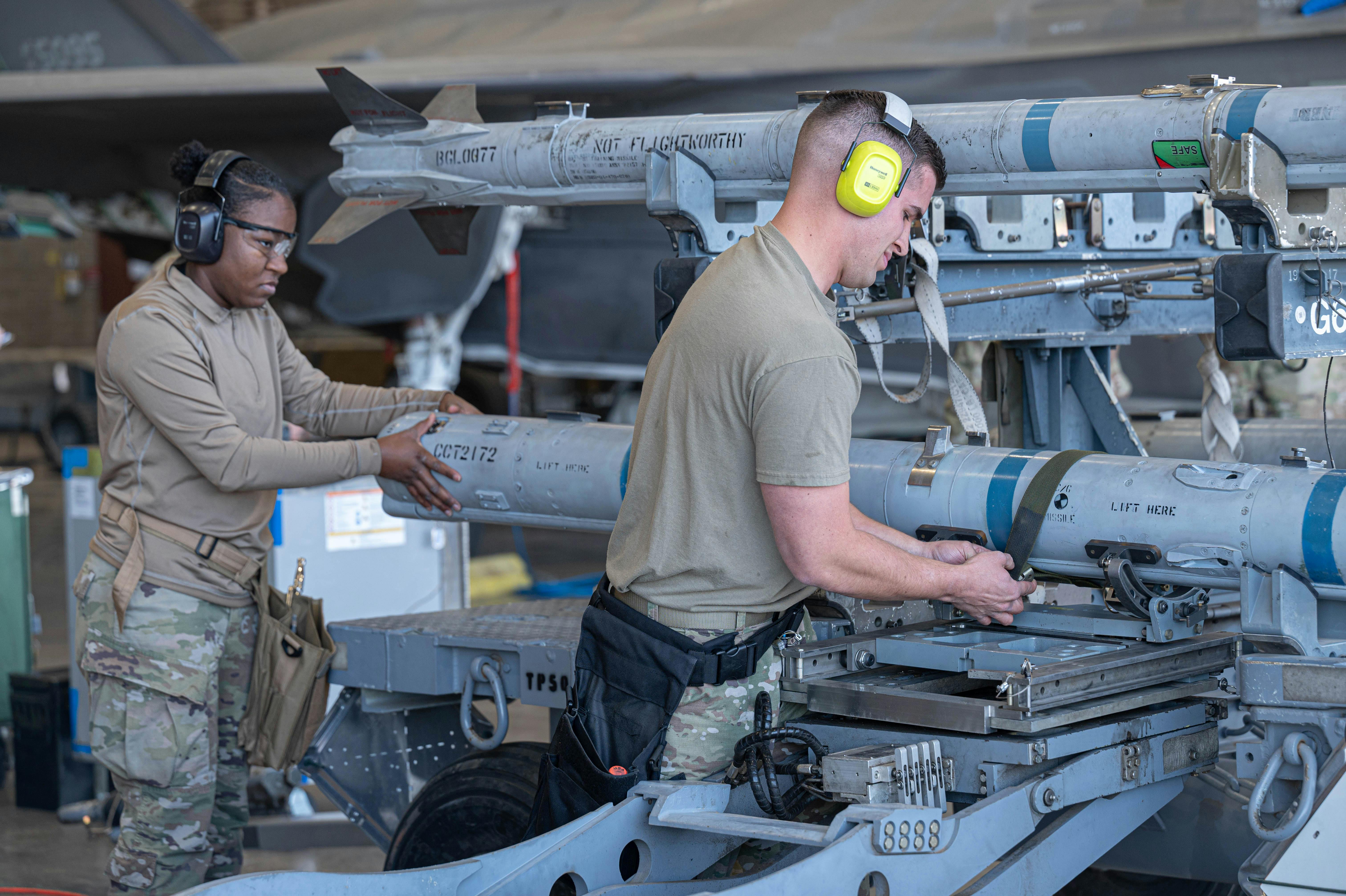 U.S. Air Force Airman 1st Class Tyeisha Duncan and Staff Sgt. Hosler Whitney, 61st Aircraft Maintenance Unit maintainer, secures an AIM-120 AMRAAM missile during the 56th Maintenance Group 2nd quarter weapons load competition at Luke Air Force Base, Ariz. U.S. Air Force photo by Airman Tekorey Watkins.