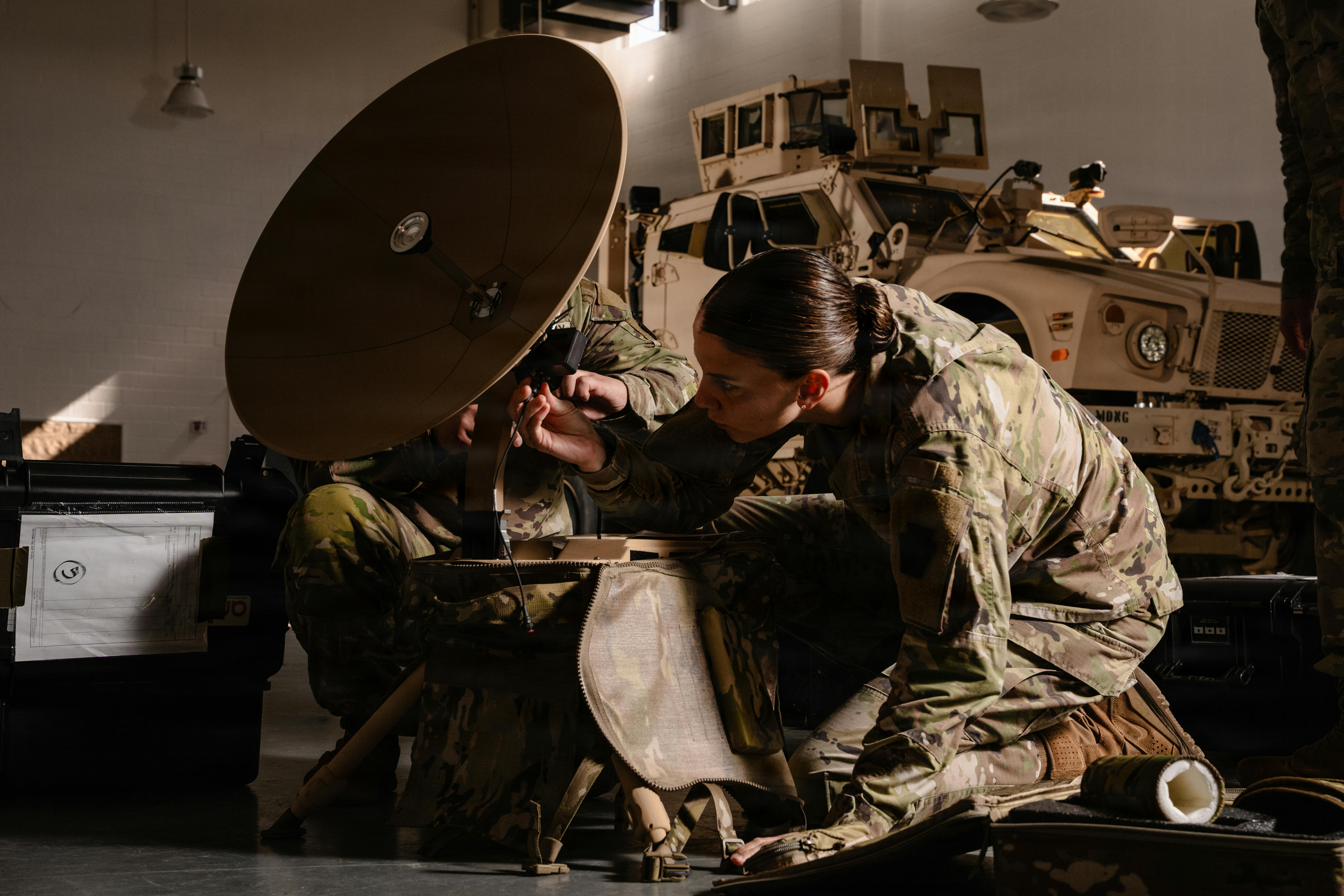 U.S. Army 2nd Lt. Eleanor Simmons, a military intelligence officer with the 628th Intelligence and Electronic Warfare Battalion, connects wires to a Global Broadcast Service AN/TSR-11 in Laurel, Md. U.S. Army National Guard photo by Staff Sgt. Thomas Lamb and Sgt. Joshua Whitaker.